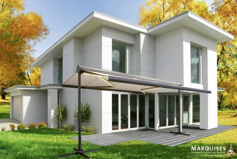 Haus mit verfärbten Baumen im Hintergrund und einer Markise im Garten
