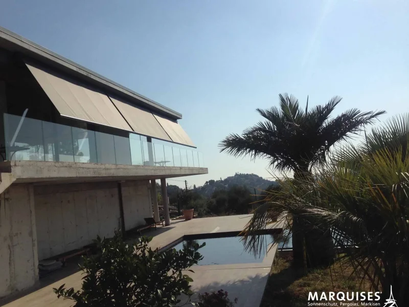 Markise an einem Haus neben einem Pool und einer Palme