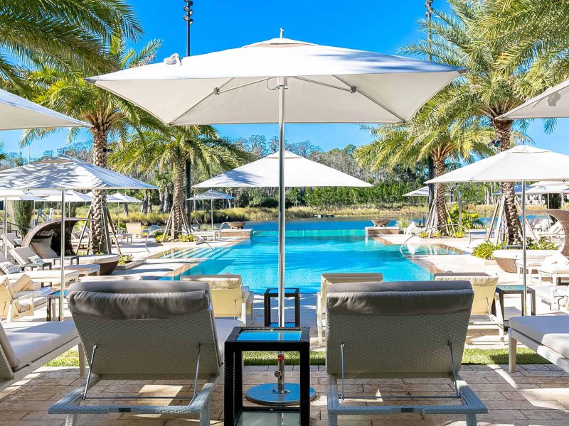 Ein Lamellendach gewährt optimalen Sonnenschutz, damit man unter dem strahlend blauen Himmel entspannen kann – sei es am erfrischenden Pool oder auf eleganten Outdoor-Möbeln.