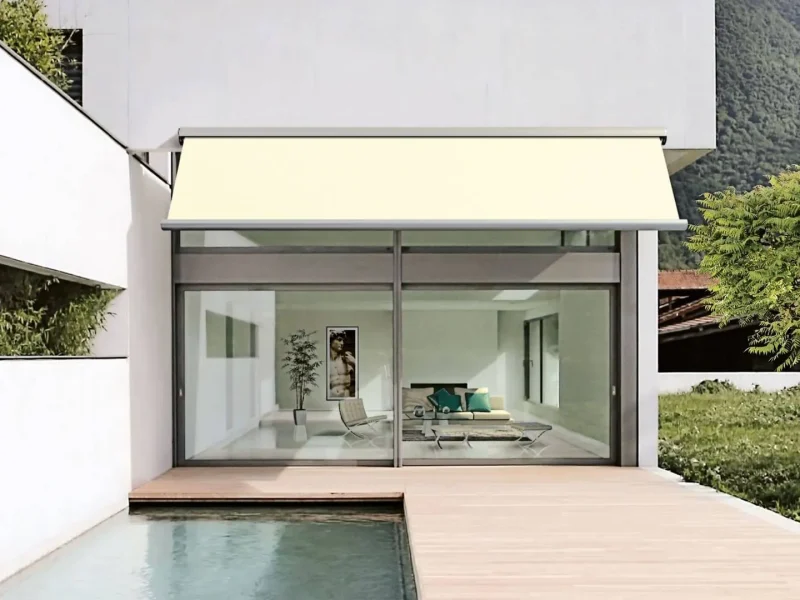 Terrasse mit einer kleinen Wasserfläche daneben, mit Blick auf eine verglaste Front.