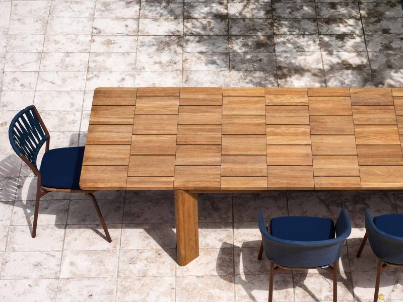 Gartentisch aus Teakholz auf einer sonnigen Veranda.