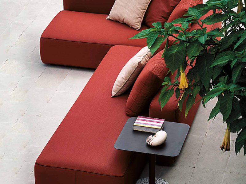 Rotes Ecksofa in einem Wintergarten.