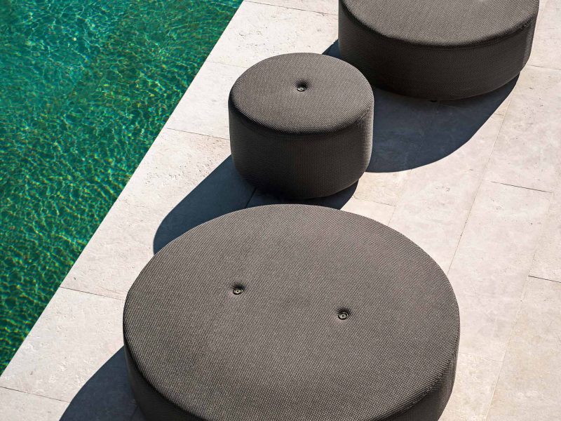 Runde Sessel stehen am Rand eines Pools.