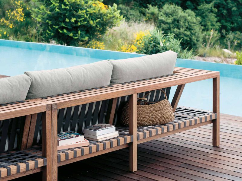 Nahaufnahme einer Couch mit weißen Polstern auf einer Terrasse am Pool