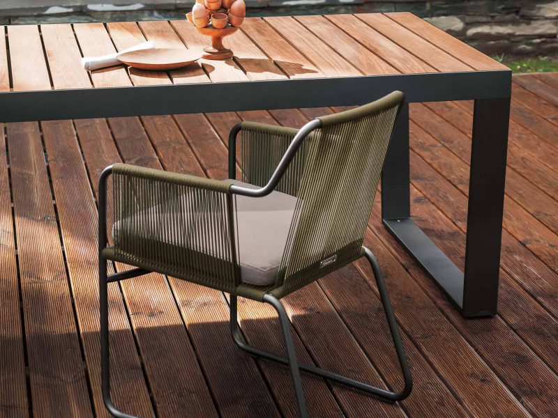 Der Stuhl steht auf einer Holzterrasse am Tisch