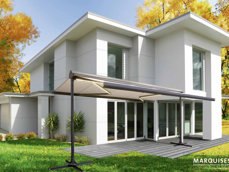 Haus mit verfärbten Baumen im Hintergrund und einer Markise im Garten