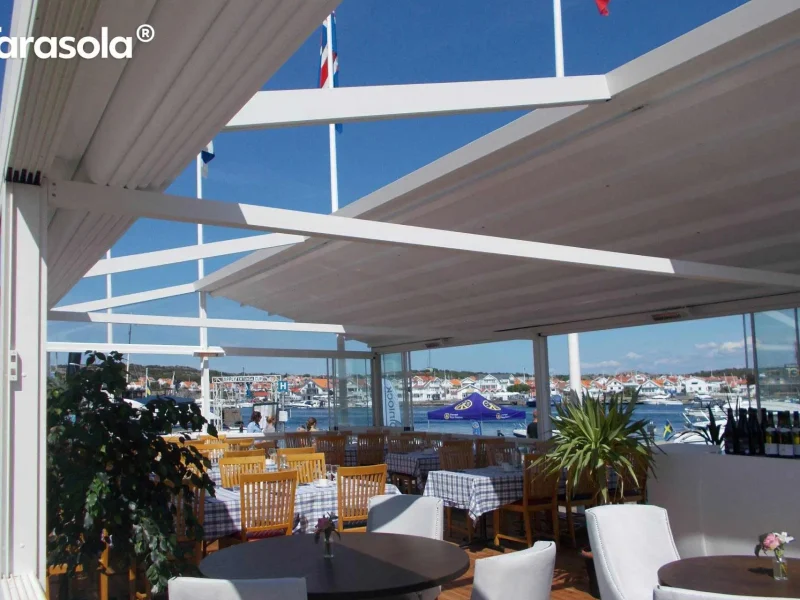Terrassenüberdachung über einer Sitzecke unter blauem Himmel